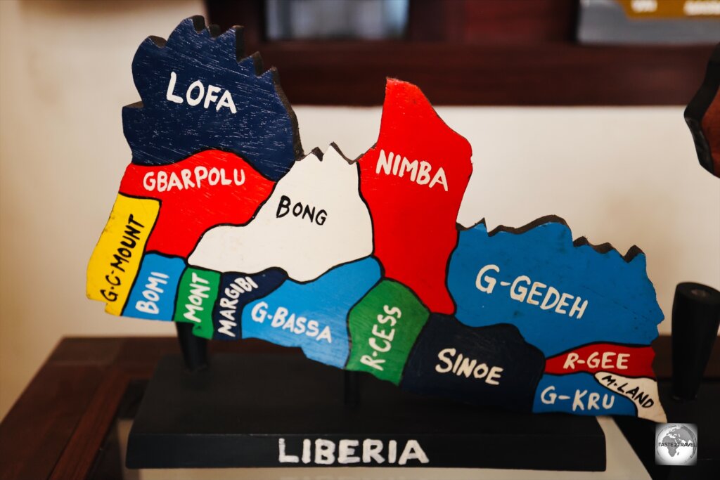 A souvenir wood carving map shows the 15 counties of Liberia.