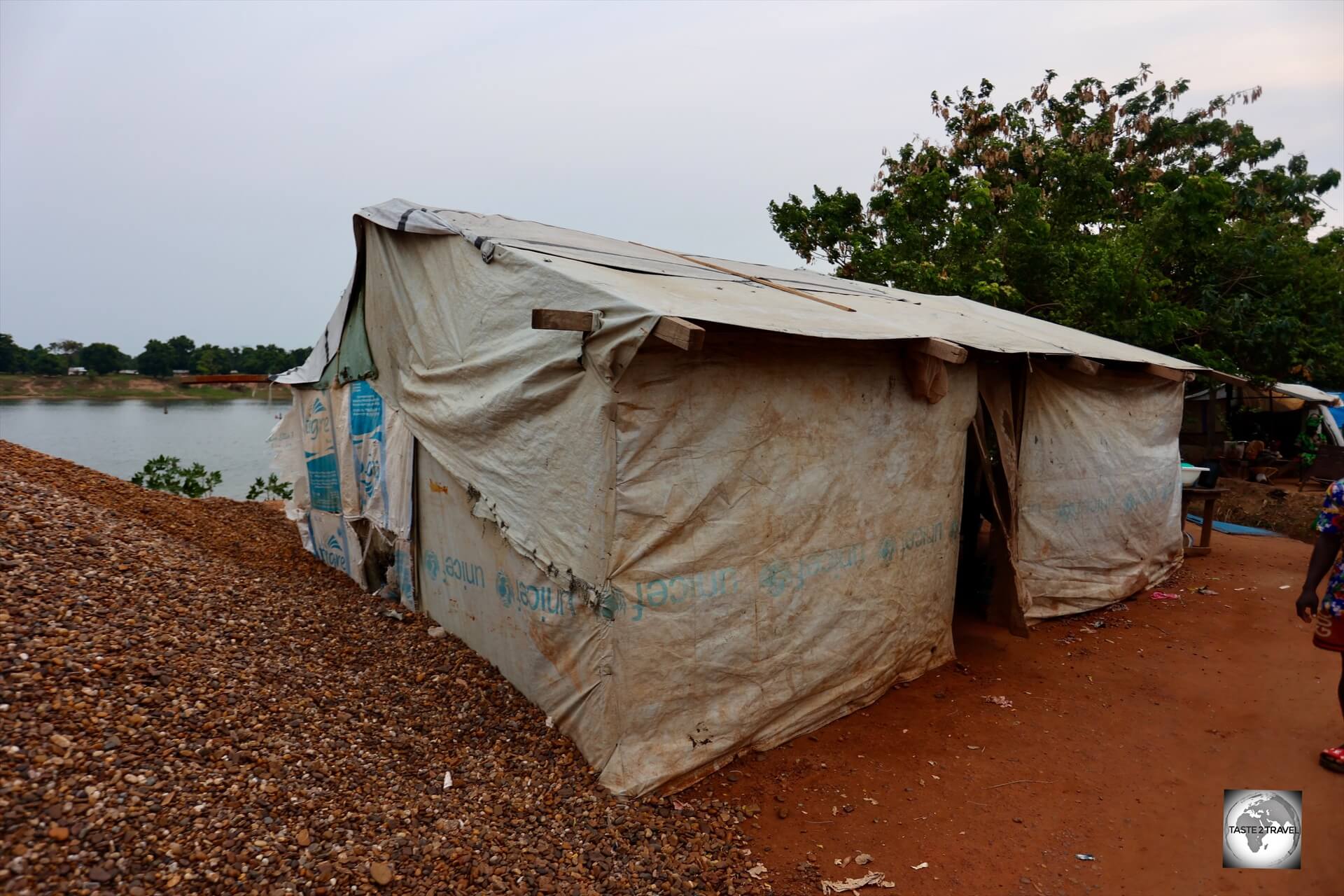 The United Nations has provided tarpaulin sheets which has allowed the refugees to build basic shelters which overlook their former island home (background).