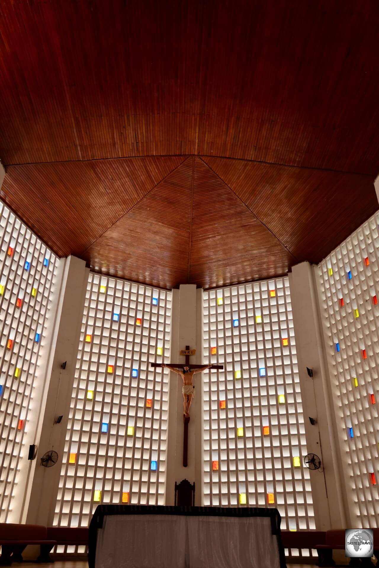 The interior of the Notre-Dame of Bangui Cathedral features a crucifix and four massive windows featuring coloured glass.