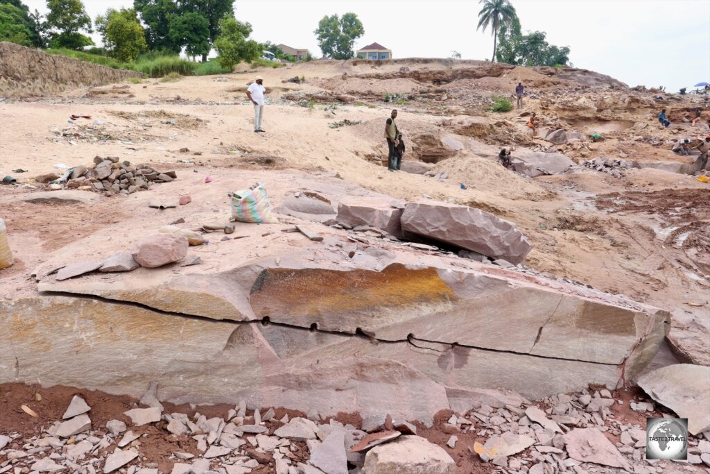 A view of the pink sandstone quarry on the banks of the Congo River, where hard-working labourers use hammer and chisels to chip away the sandstone bedrock manually.
