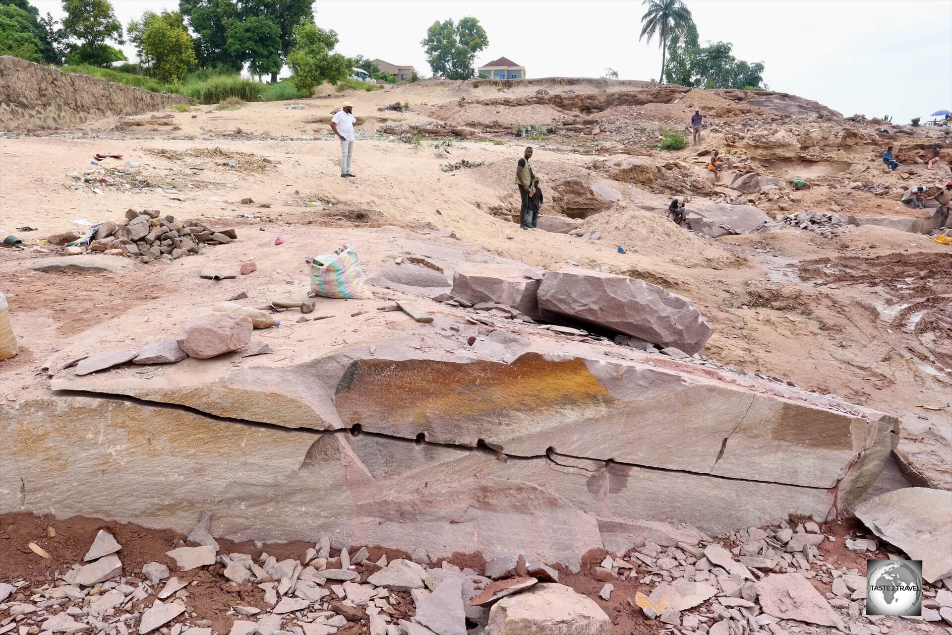 A view of the pink sandstone quarry on the banks of the Congo River, where hard-working labourers use hammer and chisels to chip away the sandstone bedrock manually.