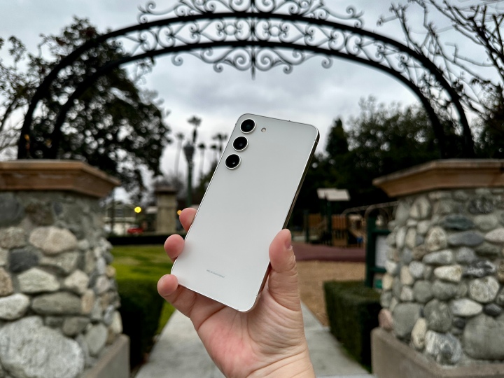 Samsung Galaxy S23 held in hand angled slightly to show off Cream color