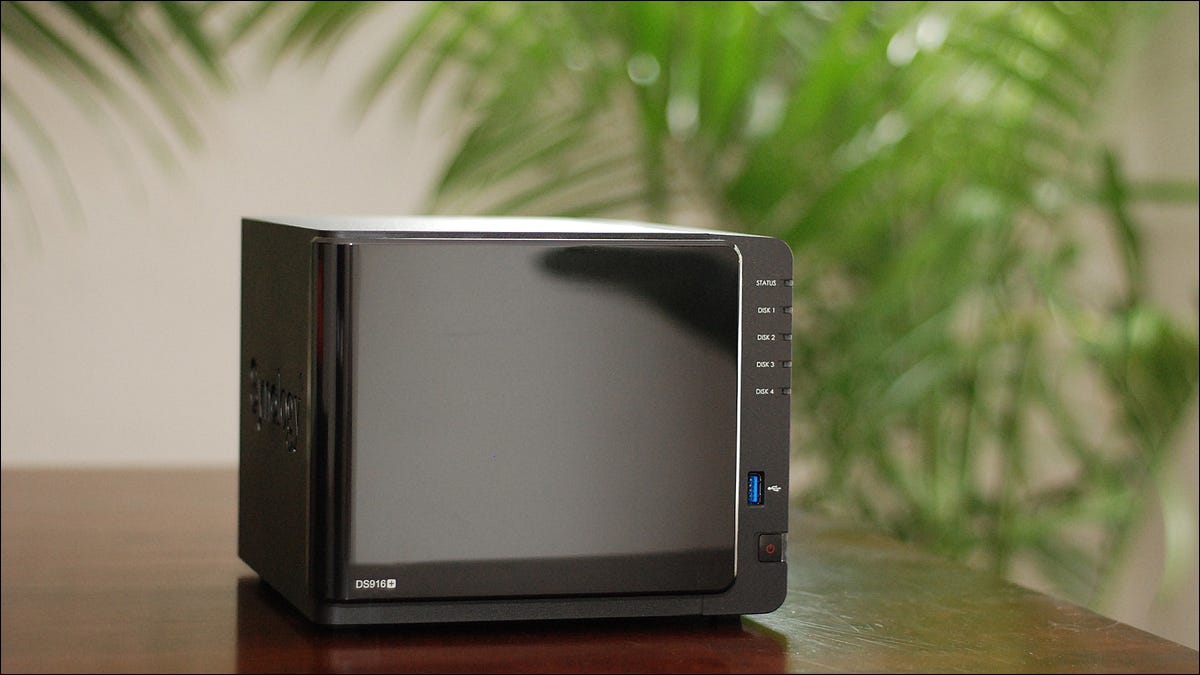 A Synology brand NAS sitting on a table in a sunny room.