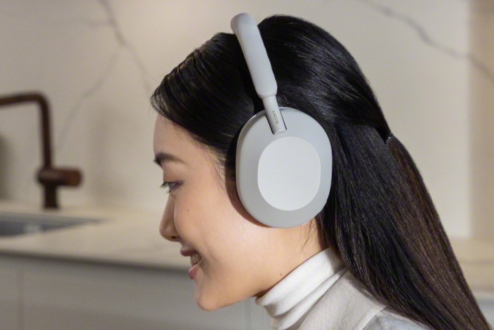 Woman wearing Sony WH-1000XM5 headphones.