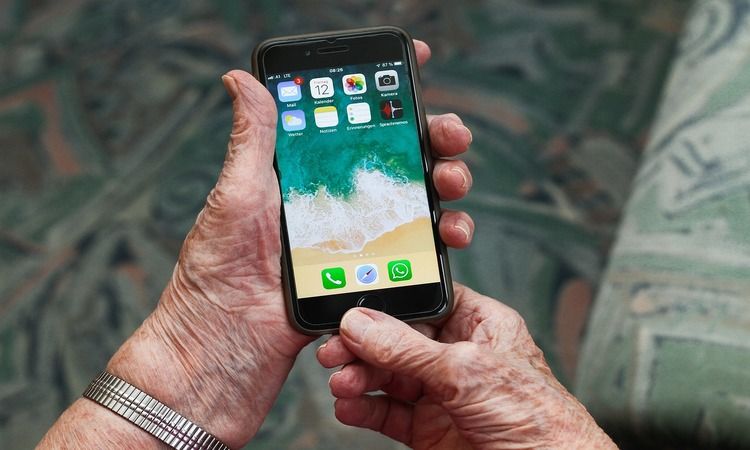 older senior holding unlocked smartphone on homescreen