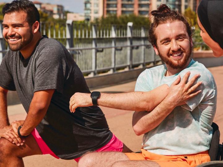 A young man wears a Fitbit Versa 4 as he gets ready to workout.