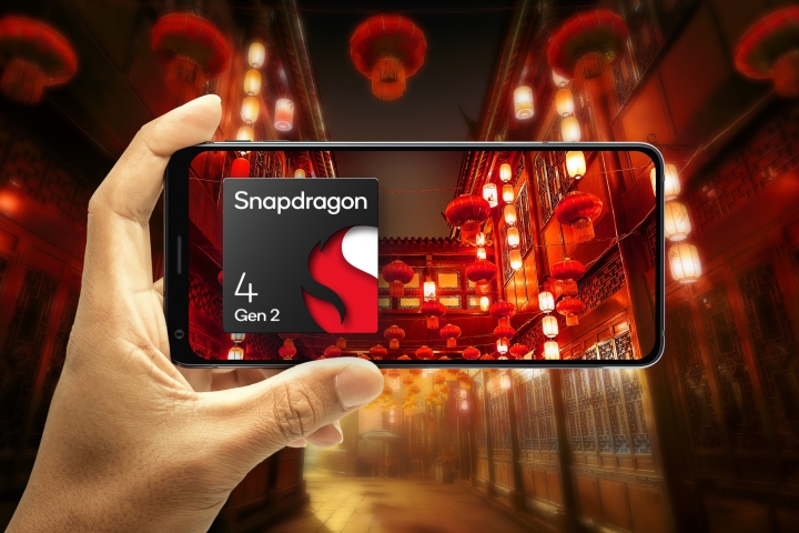 Hand holding phone in landscape orientation focusing on an illustrated scene of Chinese lanterns with Qualcomm Snapdragon 4 Gen 2 logo.