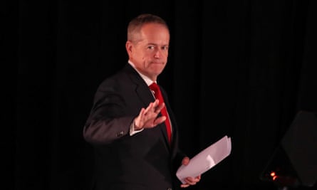Bill Shorten makes a resigned wave to supporters from a podium