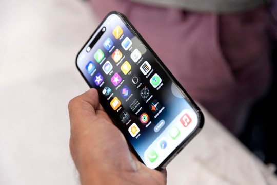 An Apple associate holds one of the new iPhone Pros during a launch event for new products at Apple headquarters in Cupertino, California, on September 7, 2022. - Apple unveiled several new products including a new iPhone 14 and 14 Pro, three Apple watches, and new AirPod Pros during the event. (Photo by Brittany Hosea-Small / AFP) (Photo by BRITTANY HOSEA-SMALL/AFP via Getty Images)