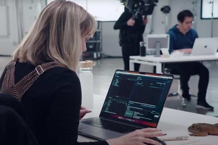 A woman using a MacBook Pro in a studio.