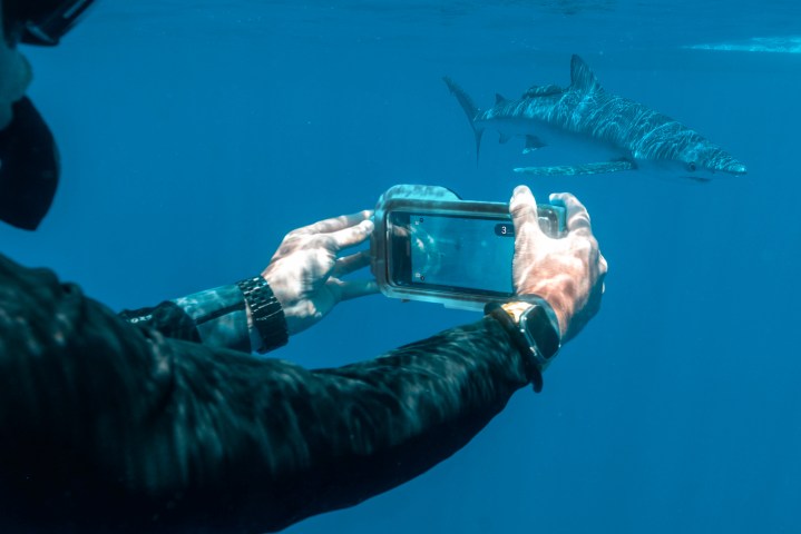 A person using the Oceanic+ Dive Housing.