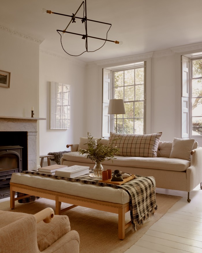 The ground floor living room. Above the fireplace is an artwork by Alfred Wallis; by the window is a piece by Rachel Whiteread. The sofa is from BDDW and the footstool from Howe antiques