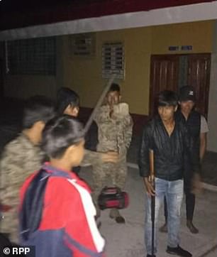 Unable to carry on with their daily lives in the village, which is approximately 10 hours by river from the Loreto region's capital city of Iquitos in north Peru, these Ikitu locals (above) organized into night patrols to hunt down their high-tech, gold cartel attackers