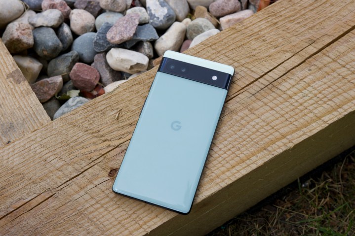 The Google Pixel 6a. We see the back of the phone as it's laying on top a piece of wood.