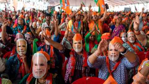 Bharatiya Janata Party (BJP) supporters wear masks of Indian Prime Minister Narendra Modi during an election rally