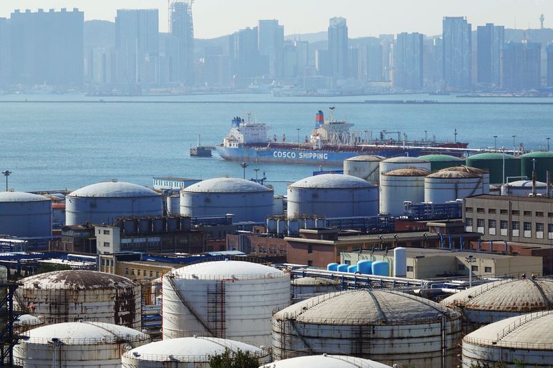 © Reuters. FILE PHOTO: A China Ocean Shipping Company (COSCO) vessel is seen near oil tanks at the China National Petroleum Corporation (CNPC)'s Dalian Petrochemical Corp in Dalian, Liaoning province, China October 15, 2019. REUTERS/Stringer/File photo