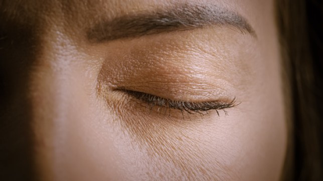 Close Up Macro Shot of an Closed Eye. Young Beatiful Female With Closed Eye. Mascara is Applied to Eyelashes. Dilating Black Pupil.