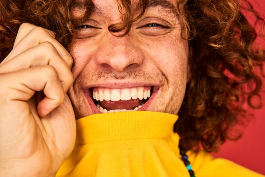 Colourful studio portrait of a young man laughing