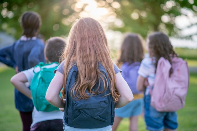 Elementary students carrying their backpacks