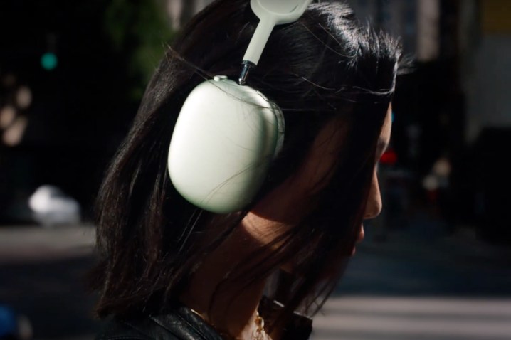 A girl wearing the green version of the Apple AirPods Max.