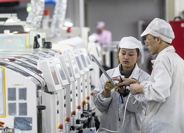 People work on machines at the Foxconn factory in Guiyang, Guizhou Province, China, that produces tech for Apple and several other IT companies