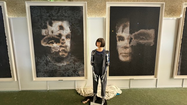 epa11709039 (FILE) - An undated handout photo made available by Sotheby's on 01 November 2024 shows the Ai-Da Robot in front of their AI created 'A.I. God. Portrait of Alan Turing' artwork, at the United Nations in Geneva, Switzerland (re-issued 08 November 2024). A 2.2 metre portrait of mathematician Alan Turing created by "Ai-Da," the world???s first ultra-realistic robot artist, became the first artwork by a humanoid robot to be sold at auction, fetching $1.32 million (1.22 million euros) at Sotheby???s Digital Art Sale in London on 07 November 2024. EPA/SOTHEBY'S HANDOUT MANDATORY CREDIT HANDOUT EDITORIAL USE ONLY/NO SALESHANDOUT EDITORIAL USE ONLY/NO SALES