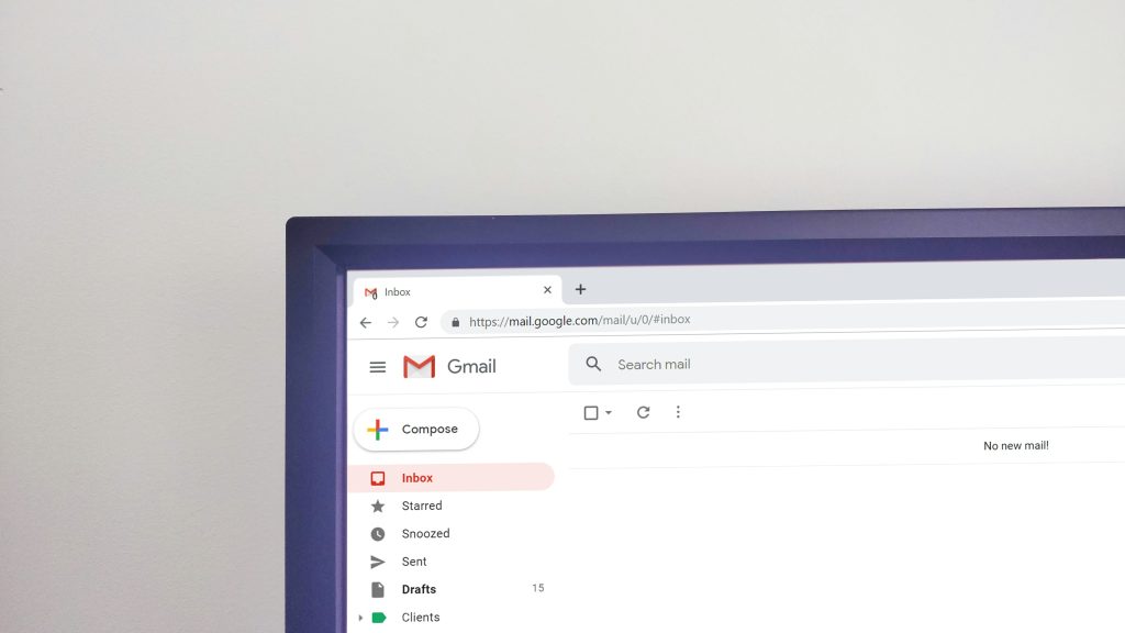 Gmail-indbakke vises på en skærm med Mapper som Indbakke, Udkast og Sendt i en browser mod en hvid væg.