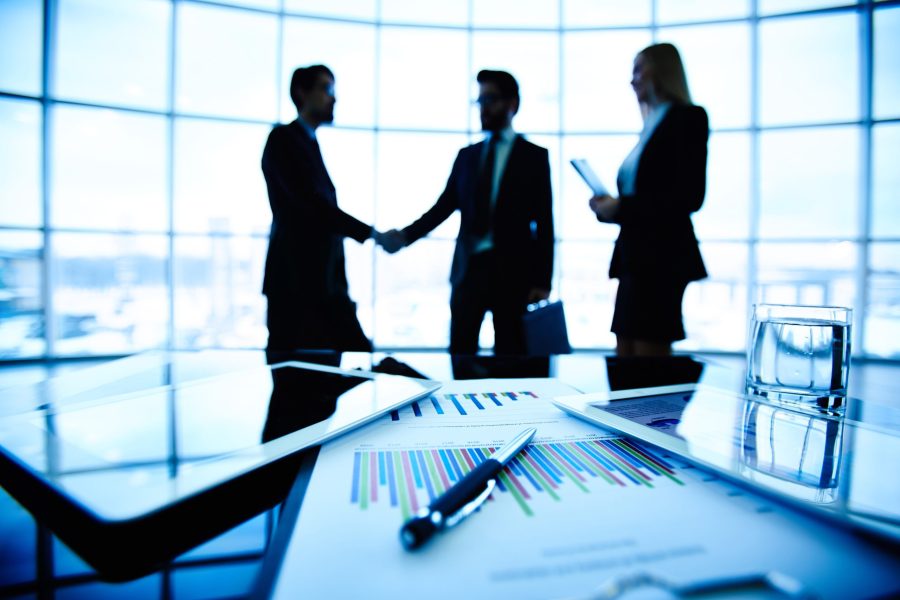 close-up-bar-graph-with-executives-negotiating-background-min