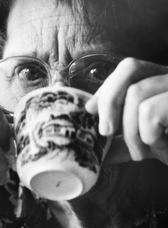 En äldre kvinna dricker kaffe