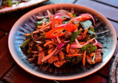 Laap Pèt: Viande de canard émincée accompagnée de menthe, de coriandre, de jeunes oignons et saupoudrée de riz gluant grillé pilé.