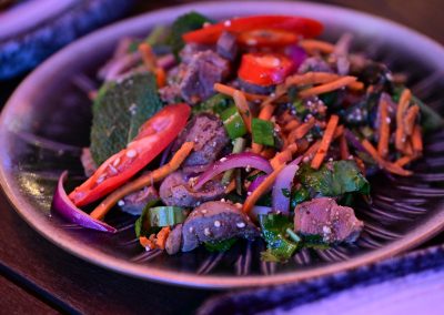 Laap Nua: Viande de bœuf émincée accompagnée de menthe, de coriandre, de jeunes oignons et saupoudrée de riz gluant grillé pilé.