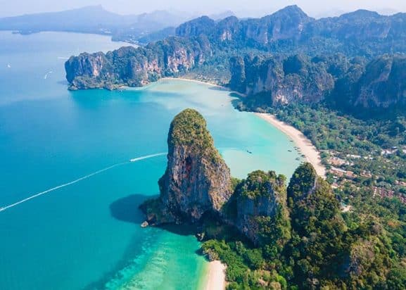 Panoramic drone view of Railay Beach in Krabi, Thailand, in the morning, featuring the tropical landscape and cloudy sky.