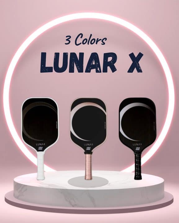 Three Lunar X pickleball paddles in white, rose gold, and black displayed on a marble pedestal, highlighted by a neon pink glow with text above stating "3 Colors LUNAR X", denoting the variety and USA Pickleball approval for tournament play.