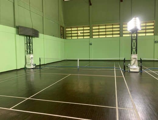 Indoor pickleball court at The Imperial Chiang Mai Resort with a wooden floor, temporary nets, and green walls.