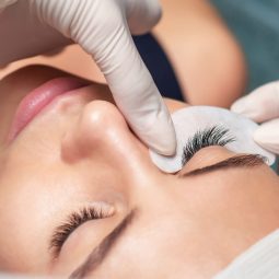 Young woman receiving extending the eyelashes in a beauty salon, close up, eyelash extension procedure.