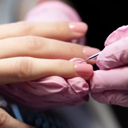 Manicurist doing gel nail design for client, close up