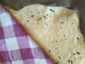 Ausgerollten veganer Focaccia-Teig noch einmal gehen lassen