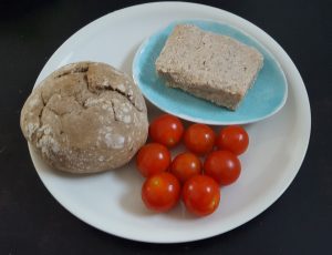 Veganer Feta in rechteckiger Form - dazu frische Tomaten, Olivenöl und Brot