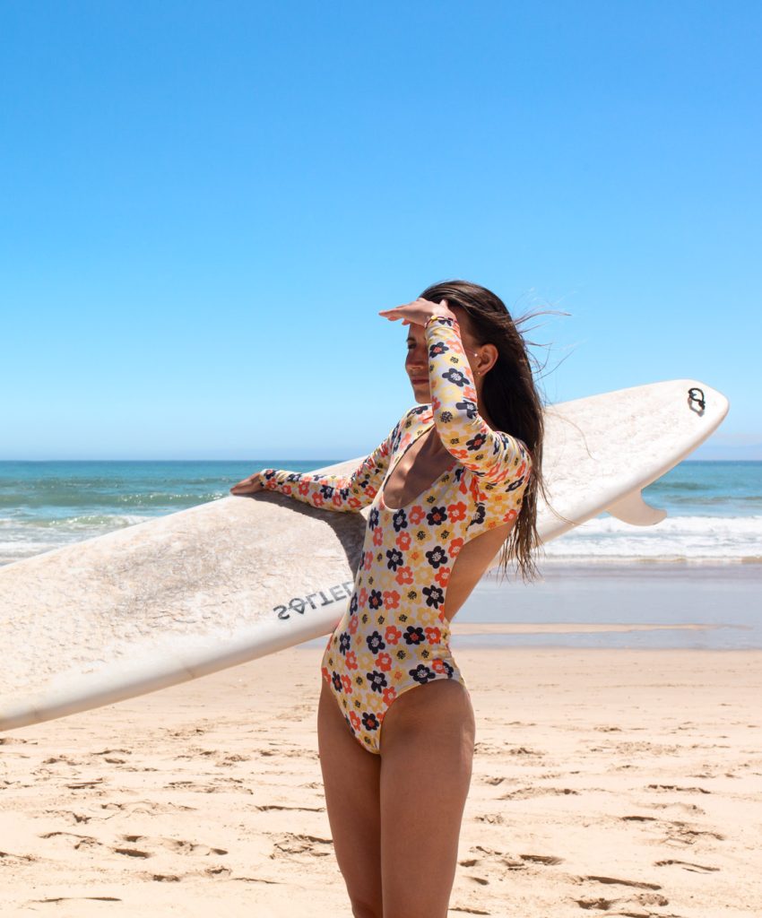 Surf girl with surfboard on the beach