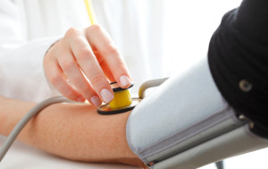 Close-up of Doctor/nurse checking blood pressure with stethoscope