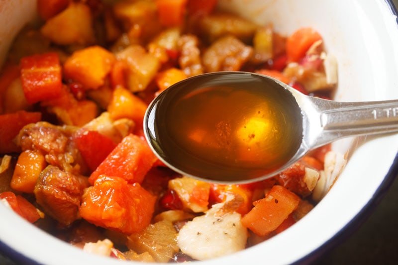 tablespoon of honey above the mixed tropical fruit salad