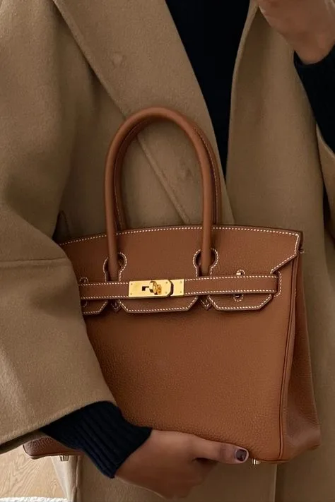 Detailed shot of a classic Hermès Birkin bag in deep brown, highlighting impeccable craftsmanship and timeless elegance.