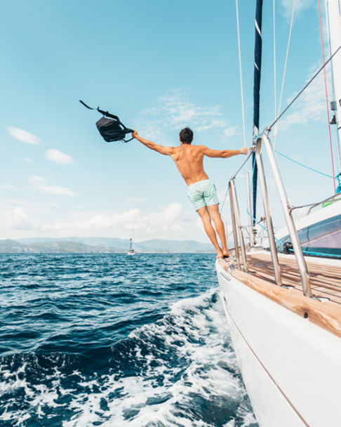 Man standing on a sailboat enjoying a holistic life and well-being 