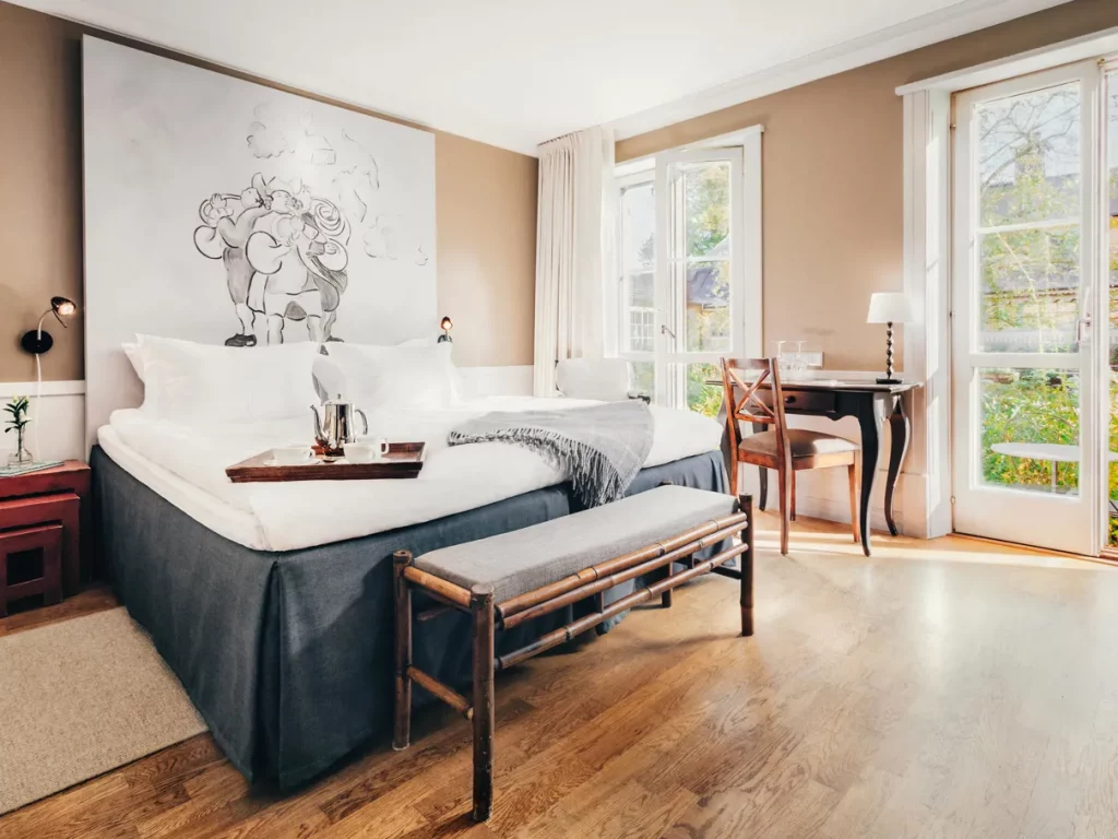 Charming bedroom interior in the farmhouse-inspired style of Stallmästaregården Hotel.