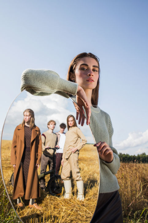 Woman standing with a mirror showcasing more people in circular fashion outfits