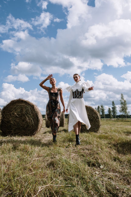 Women dancing in fashion clothes on a field.