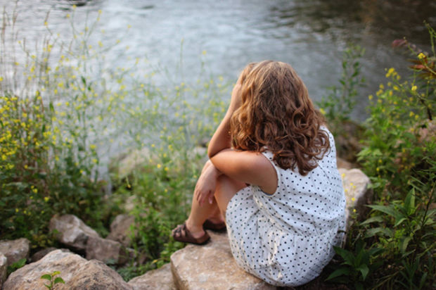 woman sitting by the water denial stage of breakup