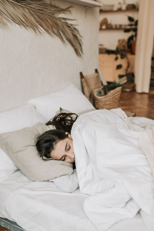 Woman sleeping alone in a bed, sad and tired