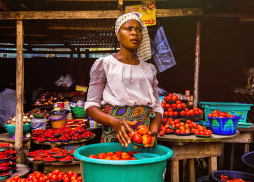 Woman in Africa culture selling tomatoes