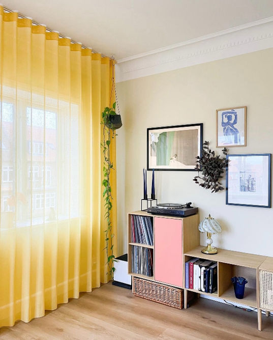 Curtains in yellow with the sun shinning through the livingroom